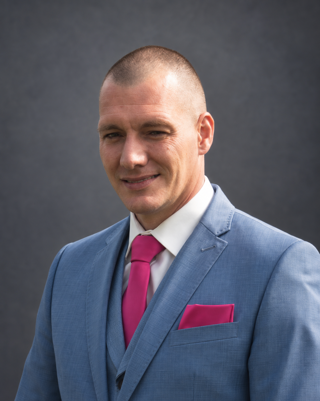 Portret van Frans in een blauw pak tegen een neutrale grijze achtergrond
